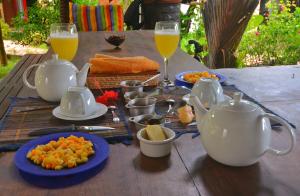 阿姆巴托洛阿卡Hotel Benjamin的餐桌,带食物盘和橙汁杯