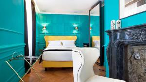 罗马Hotel The Corner Roma的卧室拥有蓝色的墙壁,配有一张床和椅子