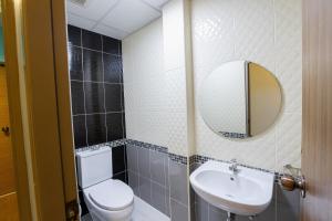 曼谷瑞思提尼旅舍的一间带卫生间、水槽和镜子的浴室