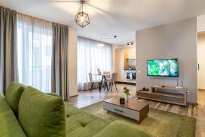 克卢日-纳波卡TCI Apartments的客厅配有绿色沙发和电视