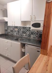 拉莫利纳Apartamento bonito Molina Alp的厨房配有白色橱柜、水槽和微波炉