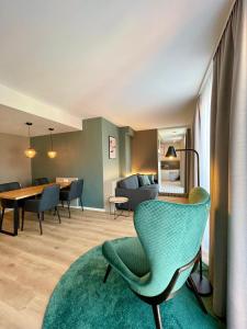埃朗根兹沃赫豪斯u套房酒店&服务式公寓的客厅配有绿色椅子和桌子