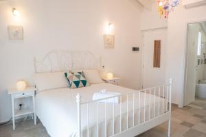 奥尔比亚Almasarda的卧室配有白色的床和婴儿床。