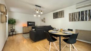 安纳马斯HOMEY WOOD - New - Appartement avec une chambre - Parking privé gratuit - Balcon privé - A 5 min de la gare pour rejoindre Genève的客厅配有桌子和沙发