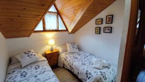 索特APARTAMENTO MUY CÉNTRICO con VISTAS - El Niuet de Sort的阁楼卧室设有两张单人床和屋顶。