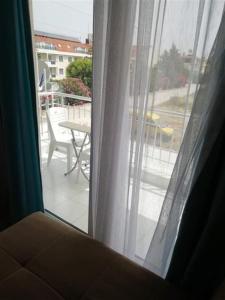 锡德Dolunaydın Butik Otel的窗户享有带桌子的阳台的景致