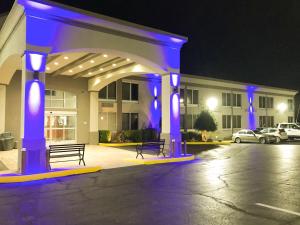 图珀洛Studio 6 Suites Tupelo, MS的停车场内有蓝色灯光的建筑