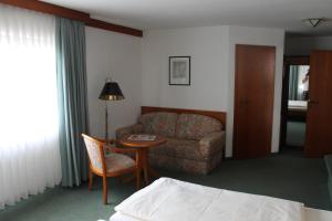 KöngenHaus Im Garten的酒店客房设有沙发、桌子和椅子。