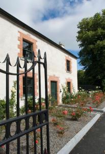 塞尔布里奇Castletown Gate House的白色建筑前的围栏,花朵