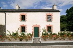 塞尔布里奇Castletown Gate House的白色的房子,有绿门和鲜花