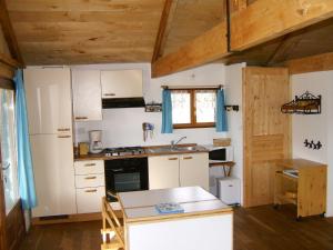 托德弗赫Paysannerie des Versanes - Chambres et gîte的一间厨房,配有白色家电和木制天花板
