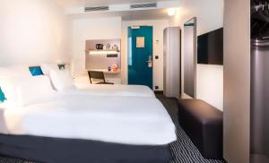 巴黎卡纳尔里贝德尔酒店的卧室配有一张白色大床和一张书桌