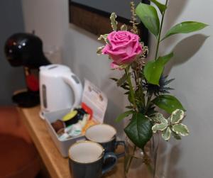 温坎顿The Nog Inn的一张花瓶,上面有粉红色的玫瑰,坐在桌子上