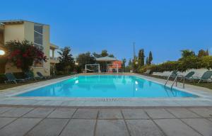 康托卡利Dreamy Apartments Corfu的大楼前的大型蓝色游泳池