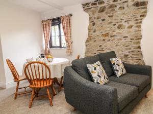 霍尔斯沃西Honey Bee Cottage的客厅配有桌子和沙发