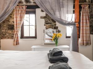 霍尔斯沃西Honey Bee Cottage的一间卧室配有带毛巾的床