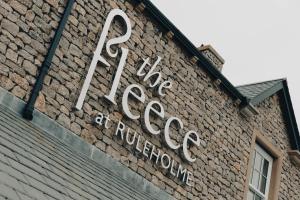 卡莱尔The Fleece at Ruleholme的砖楼边的标志