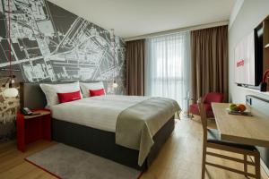 霍夫多普IntercityHotel Amsterdam Airport的酒店客房设有一张大床和一张书桌。