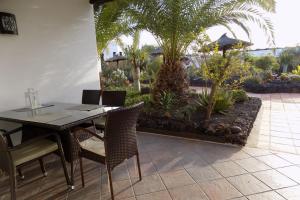 卡门港Casa Matini - Apartment next to the beach in Puerto del Carmen的一个带桌椅的用餐室和一个花园