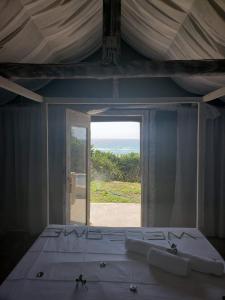 蓬塔杜欧鲁Complexo Baleia Azul Camping的一间卧室设有一张床,享有海景