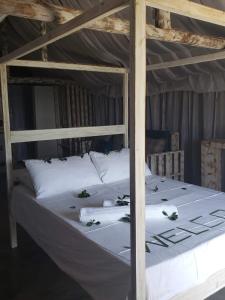 蓬塔杜欧鲁Complexo Baleia Azul Camping的一张配有白色床单和枕头的大床