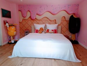 盖尔森基兴Candypartment Sweets 'n Sleep的粉红色客房内的一间卧室配有一张白色的床