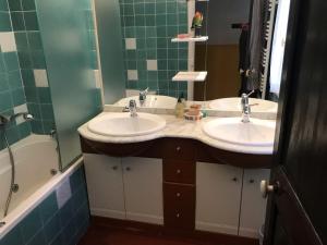 巴斯蒂亚Chambre Rose的浴室配有两个盥洗盆和浴缸。