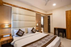 孟买Home2 Suites and Service Apartments, Mumbai Airport的一间卧室配有一张大床和一张书桌