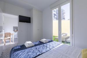 瓦伦西亚Marvellous Apt with a Large Private Terrace的白色卧室,配有带毛巾的床