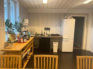 SmedjebackenHattkalles Vandrarhem的厨房配有冰箱和桌椅
