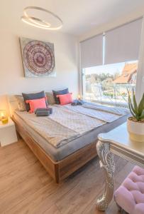 巴拉通雷勒Lelle Marine Resort Voila Apartman的一张大床,位于带大窗户的房间里