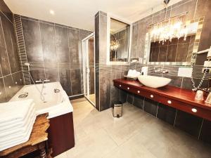 朗格勒宝斯特酒店的带浴缸、水槽和浴缸的浴室