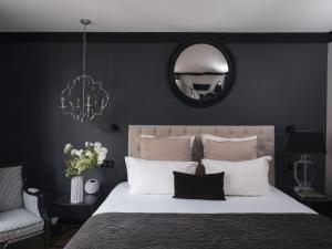 南特Maisons du Monde Hotel & Suites - Nantes的一间卧室配有一张大床和镜子