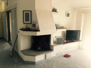 帕劳Villa con vista sull’arcipelago della Maddalena的客厅设有壁炉和电视。