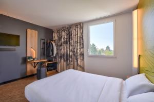 克雷泰伊B&B HOTEL Paris Créteil的酒店客房设有床和窗户。