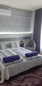 哈卡尼Lila Ház的一张大床,上面有紫色枕头