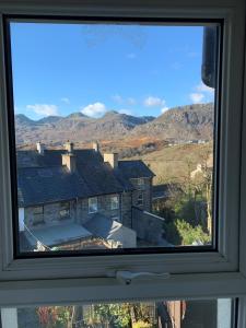 布莱奈费斯蒂尼奥格Cosy cottage in picturesque Snowdonia with stunning views of the Moelwyn mountains的从窗户可欣赏到房子的景色