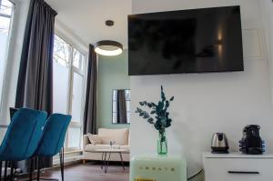慕尼黑HOMELY STAY Studio 6的客厅配有蓝色椅子和墙上的电视