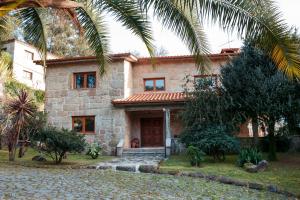 阿马里什Casa das Flores的一座石头房子,前面有棕榈树