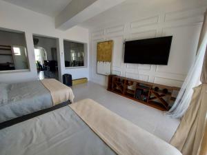 阿卡普尔科Casa Blanca Grand的一间卧室配有两张床和一台平面电视