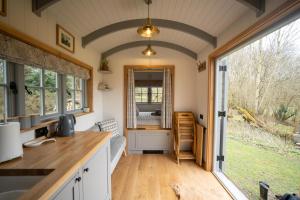 WinshamSomerset Shepherds Huts的一个小房子里带大窗户的厨房