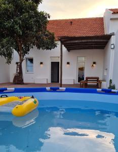 格兰杜拉Casa Magana em Grândola的水中一个黄色木筏的游泳池