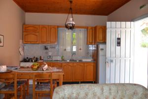 斯巴达Mihaila seaside: 2 bedroom bungalows Kefalonia的厨房配有木制橱柜和桌椅