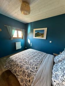 CeyssatChalets "Ô Cœur des Puys"的一间卧室配有一张蓝色墙壁的床