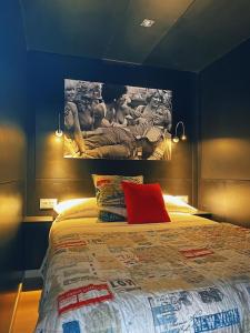 El TesoLa Villa del Karting的卧室配有一张大床,墙上挂有绘画作品