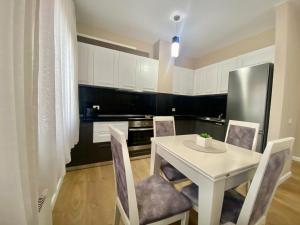 地拉那Tirana New Bazaar- Apartment no-1的厨房配有白色的桌椅和冰箱。