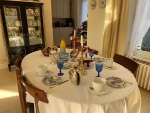 圣马洛Villa Hébert的餐桌,配有白色桌布和蓝玻璃杯