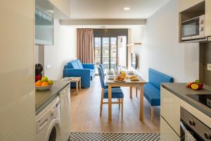 塔拉戈纳Tgna Rambla 68的厨房以及带桌子和蓝色椅子的客厅。