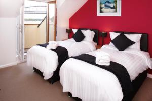 普里茅斯轮渡旅馆的红色墙壁的房间里设有三张床