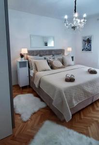 莫斯塔尔Apartman Miletic的一间卧室配有一张大床和一个吊灯。